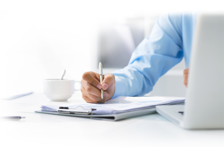 Photo of man writing at a desk